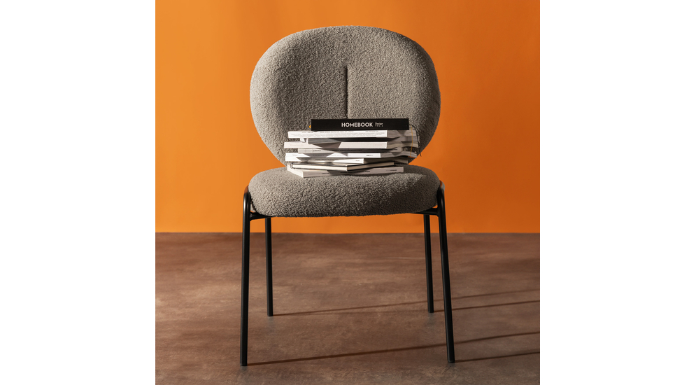 Okrągłe krzesło tapicerowane, wykończone szarym barankiem.