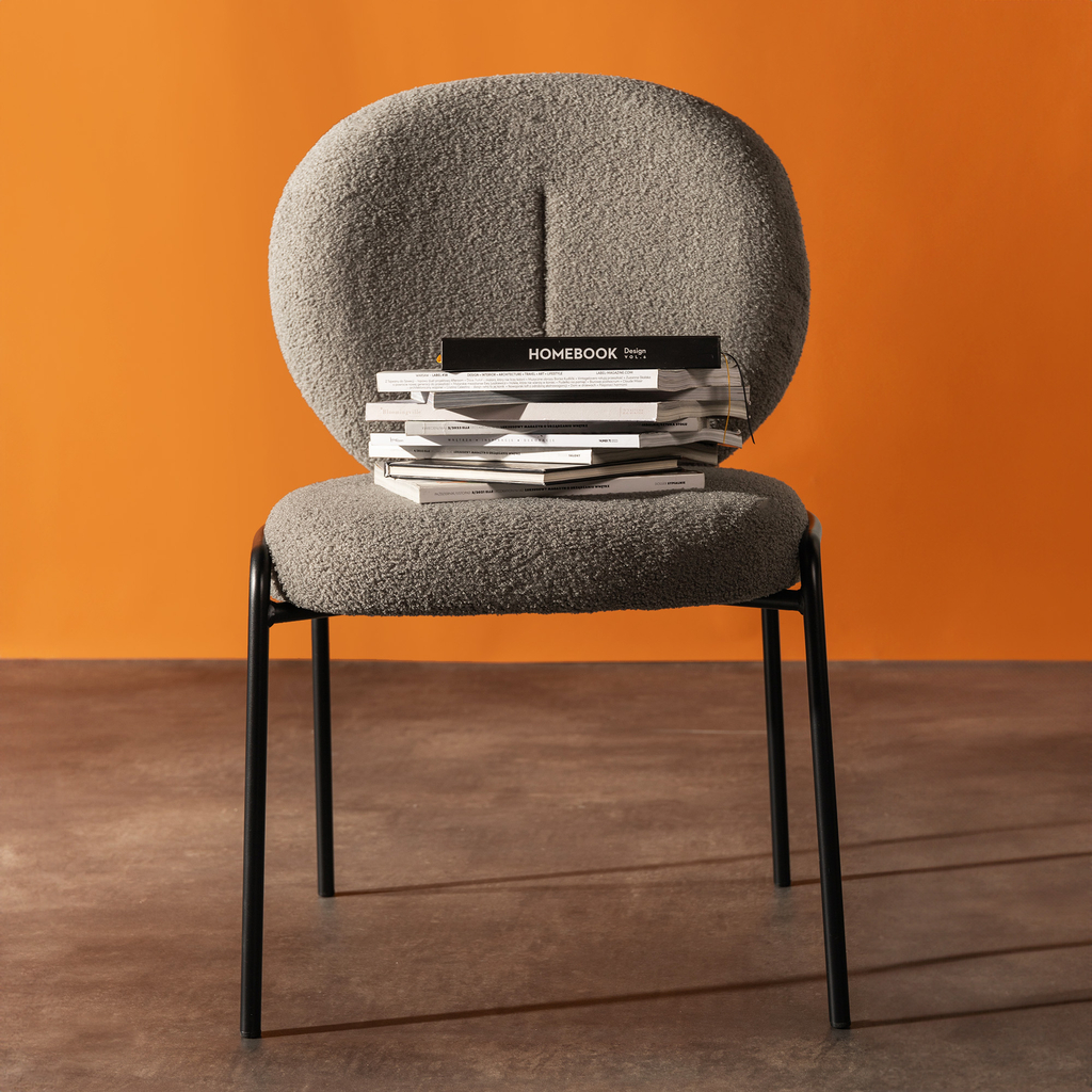 Okrągłe krzesło tapicerowane, wykończone szarym barankiem.